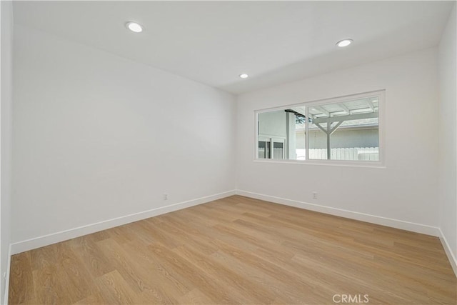 unfurnished room with recessed lighting, light wood finished floors, and baseboards