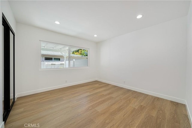 unfurnished bedroom featuring light wood-style floors, recessed lighting, and baseboards