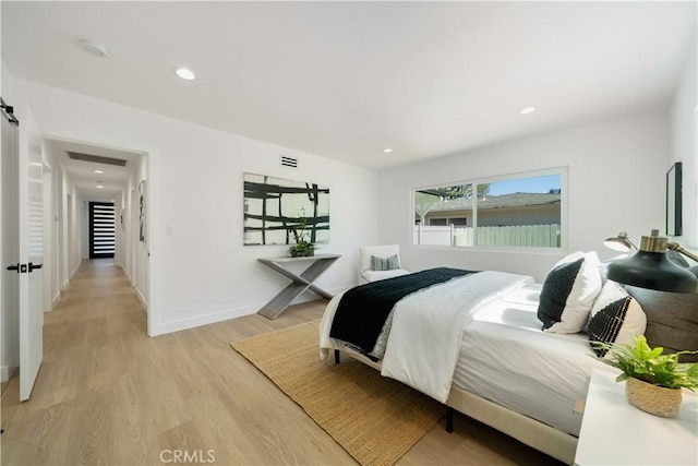 bedroom featuring light wood finished floors, recessed lighting, visible vents, and baseboards