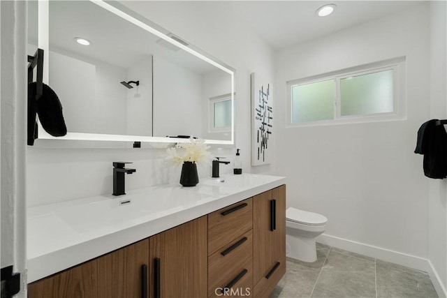 full bathroom with a sink, double vanity, a shower, baseboards, and toilet