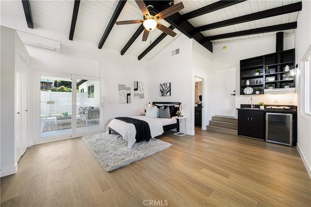 bedroom with wine cooler, access to outside, light wood-type flooring, visible vents, and wet bar