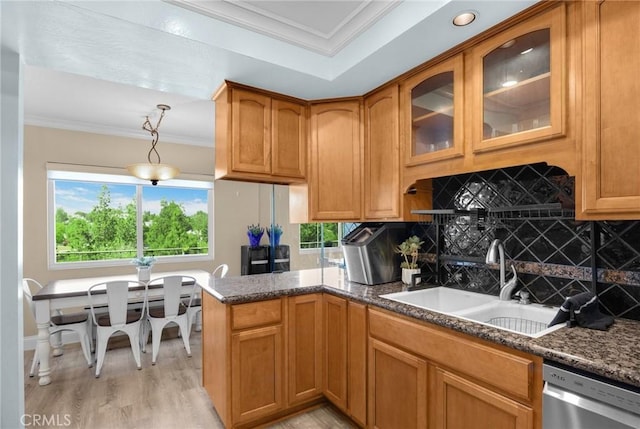 kitchen with stainless steel dishwasher, crown molding, a sink, glass insert cabinets, and light wood-style flooring