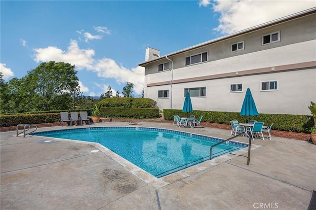 pool with outdoor dining space and a patio