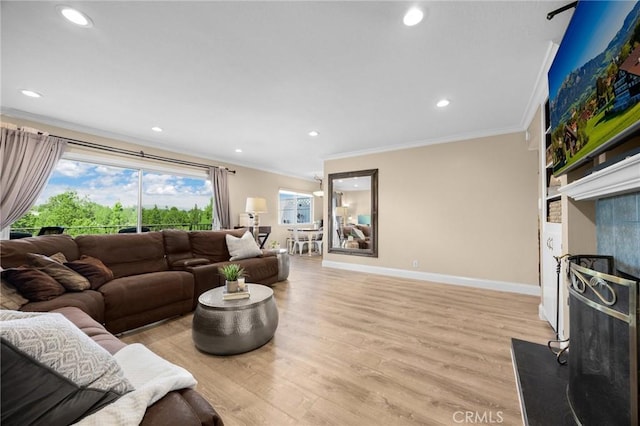 living area featuring light wood-style flooring, baseboards, recessed lighting, and crown molding