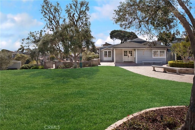 rear view of house with a chimney, french doors, a yard, and a patio