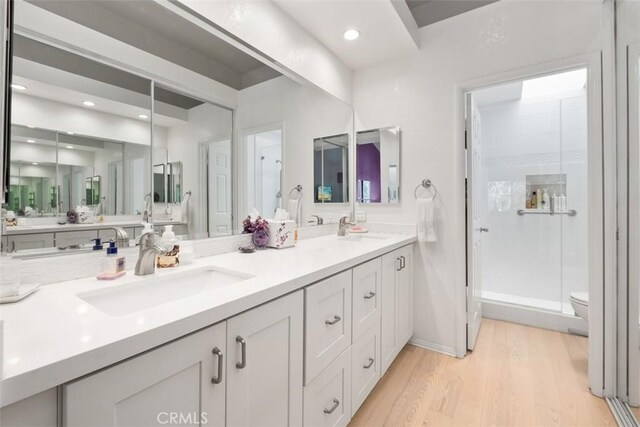 23 Pemberton Pl Unit 121, Laguna Niguel, CA 92677 - bathroom with wood finished floors, a sink, double vanity, and a stall shower