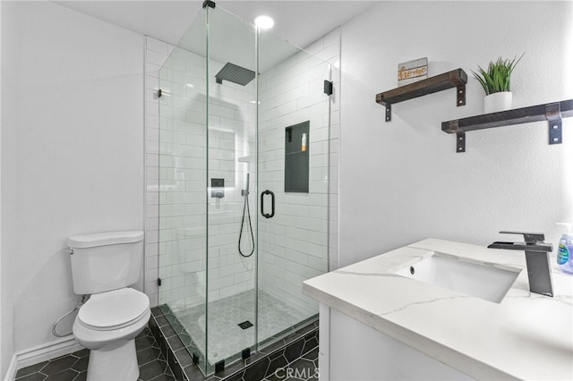 bathroom featuring tile patterned flooring, toilet, vanity, baseboards, and a stall shower