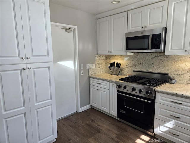 kitchen featuring white cabinetry, stainless steel microwave, gas stove, decorative backsplash, and dark wood-style flooring