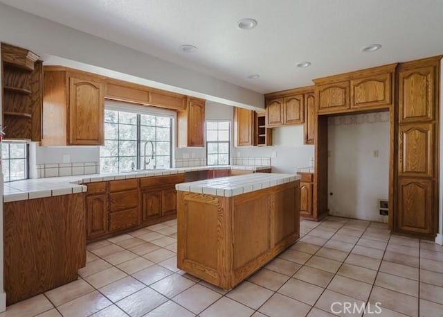 79 Indian Rock Dr, Oroville, CA 95966 - kitchen featuring light tile patterned floors, a center island, a sink, open shelves, and tile countertops