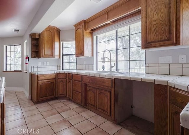 79 Indian Rock Dr, Oroville, CA 95966 - kitchen with light tile patterned floors, brown cabinetry, visible vents, a sink, and open shelves