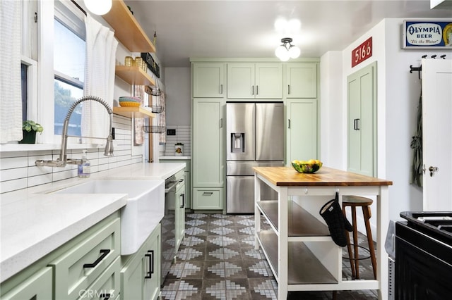 kitchen featuring open shelves, wood counters, green cabinets, and stainless steel appliances