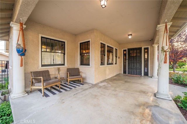 entrance to property featuring covered porch and stucco siding