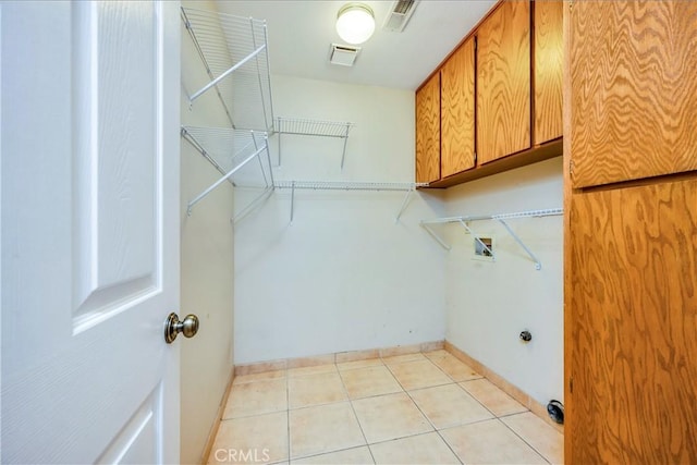 4032 Gray Stone Ct, Kelseyville, CA 95451 - clothes washing area featuring visible vents, light tile patterned floors, baseboards, cabinet space, and washer hookup