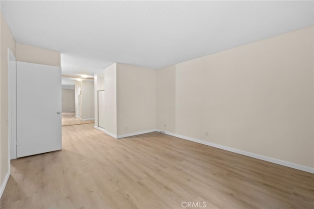 empty room featuring light wood-style floors and baseboards