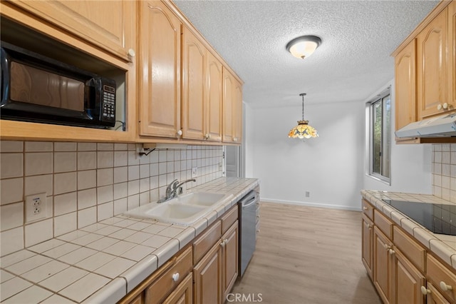 kitchen featuring baseboards, tile counters, under cabinet range hood, a sink, and black appliances