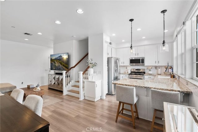 12362 Cottonwood Pl, Santa Fe Springs, CA 90670 - kitchen with appliances with stainless steel finishes, a sink, a peninsula, light stone counters, and tasteful backsplash
