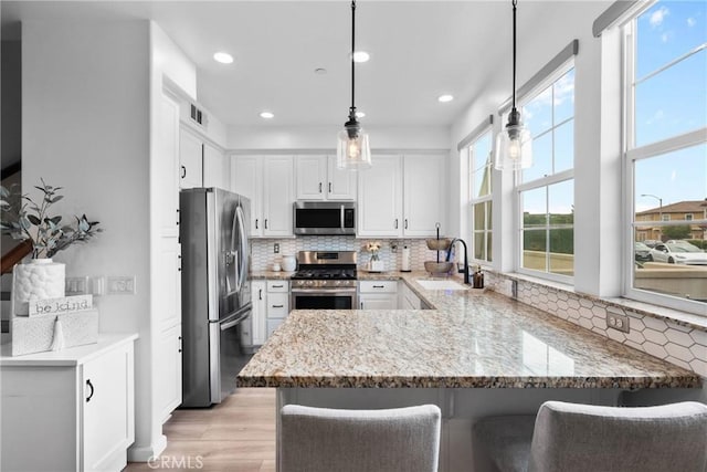12362 Cottonwood Pl, Santa Fe Springs, CA 90670 - kitchen featuring appliances with stainless steel finishes, a sink, a peninsula, light stone counters, and recessed lighting