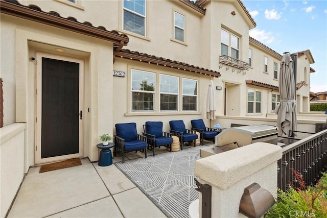 rear view of house with a patio, stucco siding, and a tiled roof