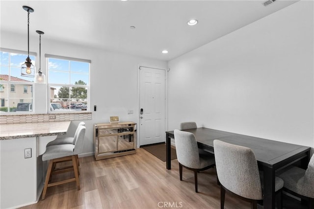dining room featuring baseboards, recessed lighting, and light wood-style flooring