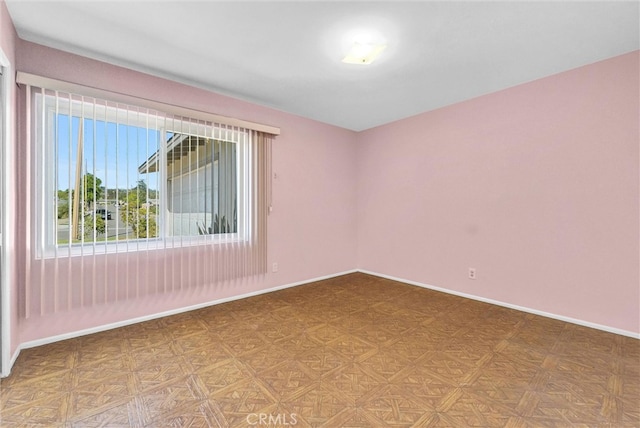 unfurnished room featuring baseboards