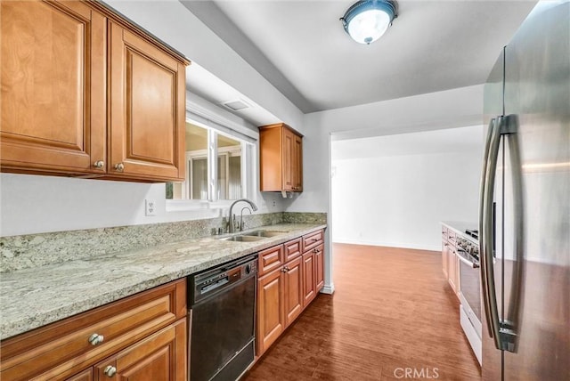 kitchen with a sink, dishwasher, light stone countertops, dark wood-style floors, and freestanding refrigerator