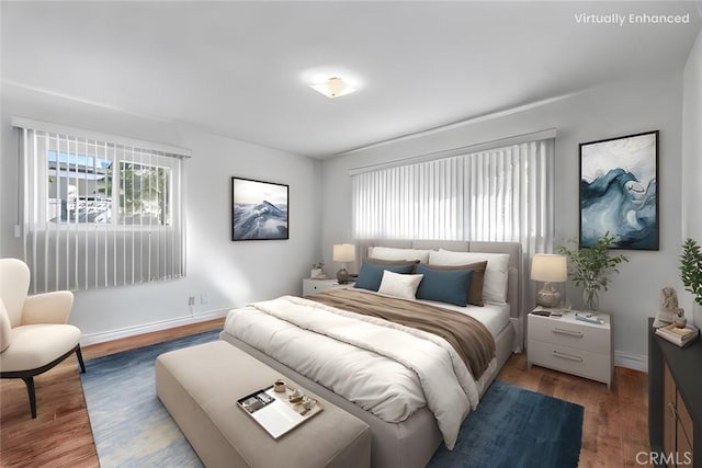 bedroom featuring wood finished floors, baseboards, and multiple windows