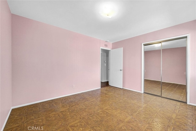 unfurnished bedroom with a closet and baseboards