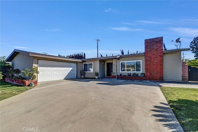 ranch-style house featuring an attached garage, a chimney, and driveway