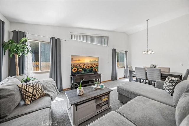 carpeted living room featuring baseboards, an inviting chandelier, and high vaulted ceiling