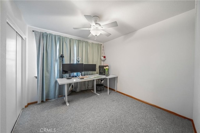 carpeted home office with baseboards and ceiling fan