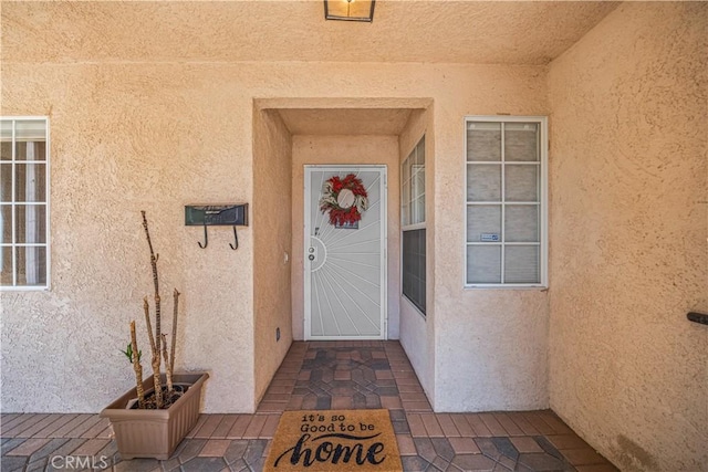 view of exterior entry featuring stucco siding