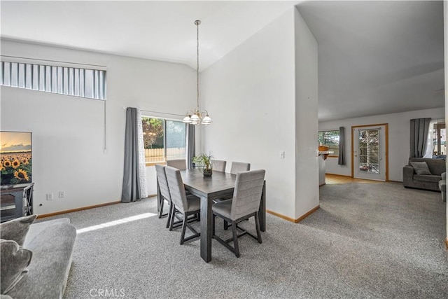 carpeted dining room featuring high vaulted ceiling, a chandelier, and baseboards