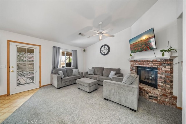 living area with a ceiling fan, visible vents, a brick fireplace, baseboards, and lofted ceiling