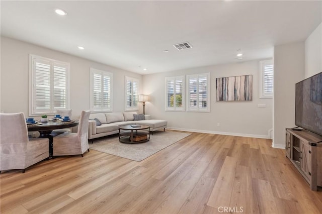 living area with baseboards, light wood-style floors, visible vents, and recessed lighting