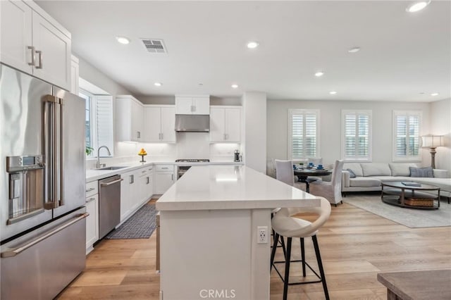 kitchen with a breakfast bar, a healthy amount of sunlight, appliances with stainless steel finishes, and a center island