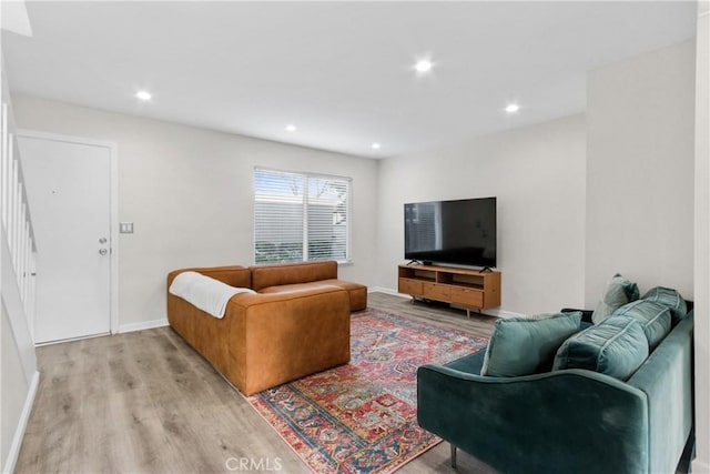 living room with light wood-style floors, recessed lighting, baseboards, and stairway