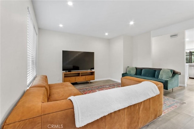 living room with light wood-style flooring, recessed lighting, and baseboards