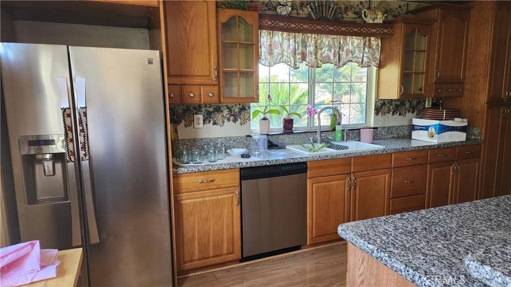 1711 S Washington Ave, Glendora, CA 91740 - kitchen featuring a sink, brown cabinetry, glass insert cabinets, and appliances with stainless steel finishes