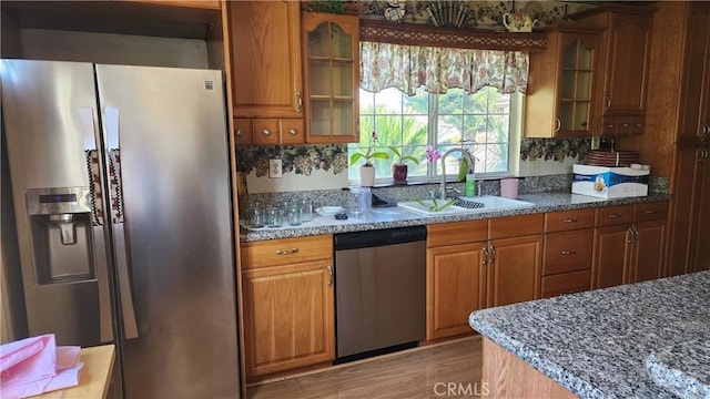 1711 S Washington Ave, Glendora, CA 91740 - kitchen with stainless steel appliances, brown cabinetry, glass insert cabinets, and light wood-style floors