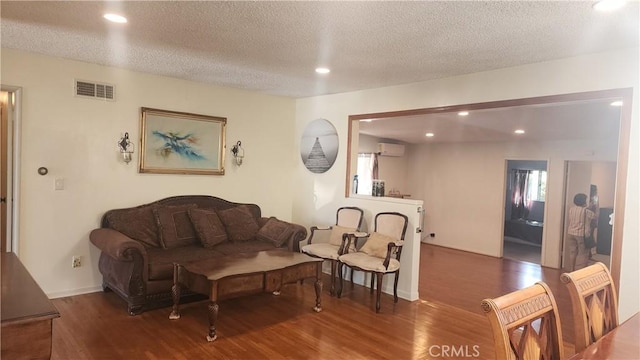 1711 S Washington Ave, Glendora, CA 91740 - living area featuring a wall unit AC, wood finished floors, a textured ceiling, and recessed lighting