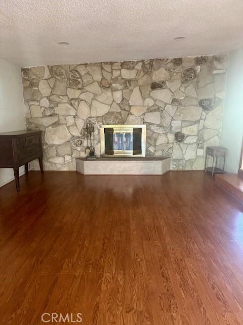 1711 S Washington Ave, Glendora, CA 91740 - unfurnished living room featuring a fireplace, a textured ceiling, and wood finished floors