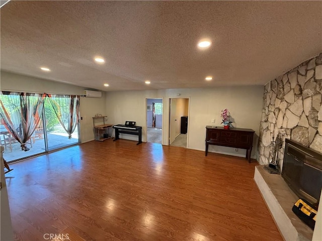 1711 S Washington Ave, Glendora, CA 91740 - exercise area featuring a textured ceiling, light wood-type flooring, recessed lighting, a stone fireplace, and a wall mounted AC