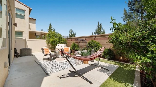 view of patio / terrace with a fenced backyard, a ceiling fan, and central air condition unit