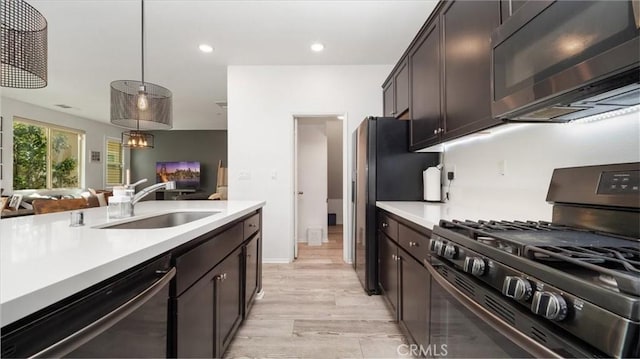 kitchen featuring a sink, light countertops, dishwasher, and gas range