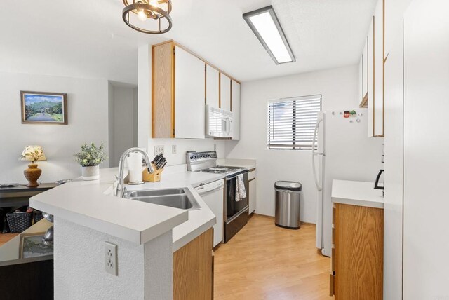 9725 Mesa Springs Way Unit 176, San Diego, CA 92126 - kitchen with white appliances, a peninsula, light wood-style flooring, and light countertops