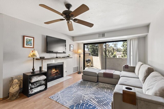 9725 Mesa Springs Way Unit 176, San Diego, CA 92126 - living room with wood finished floors, a fireplace, and a ceiling fan