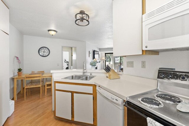 9725 Mesa Springs Way Unit 176, San Diego, CA 92126 - kitchen featuring white appliances, a peninsula, light countertops, white cabinets, and light wood finished floors