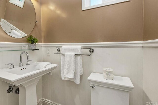 720 San Luis Obispo Pl Unit D, San Diego, CA 92109 - half bathroom featuring toilet and a wainscoted wall
