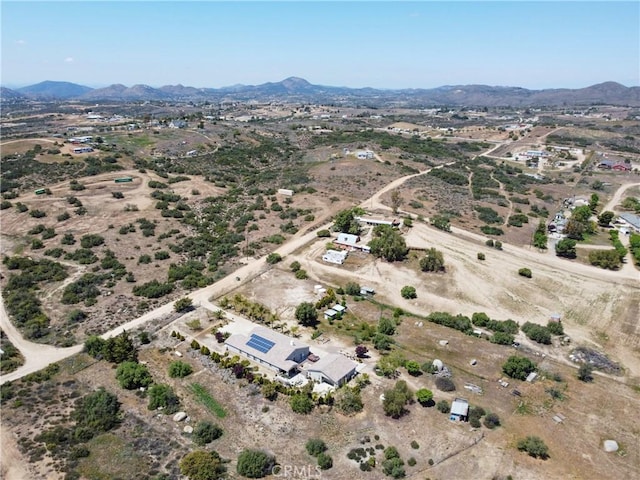 drone / aerial view with a desert view, a mountain view, and a rural view