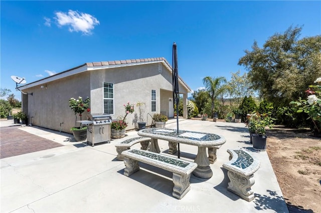 rear view of property with a patio and stucco siding